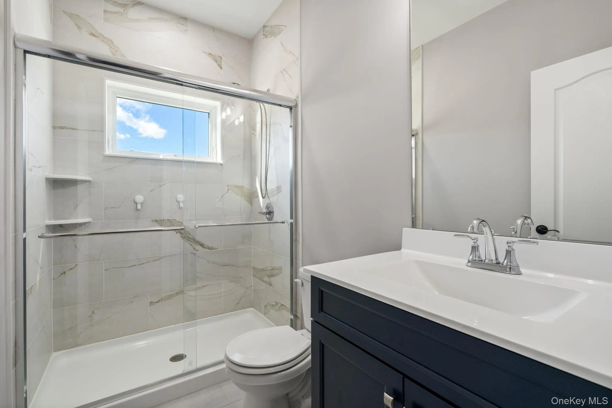 Full bath featuring vanity and a marble finish shower Full bath featuring vanity and a marble finish shower