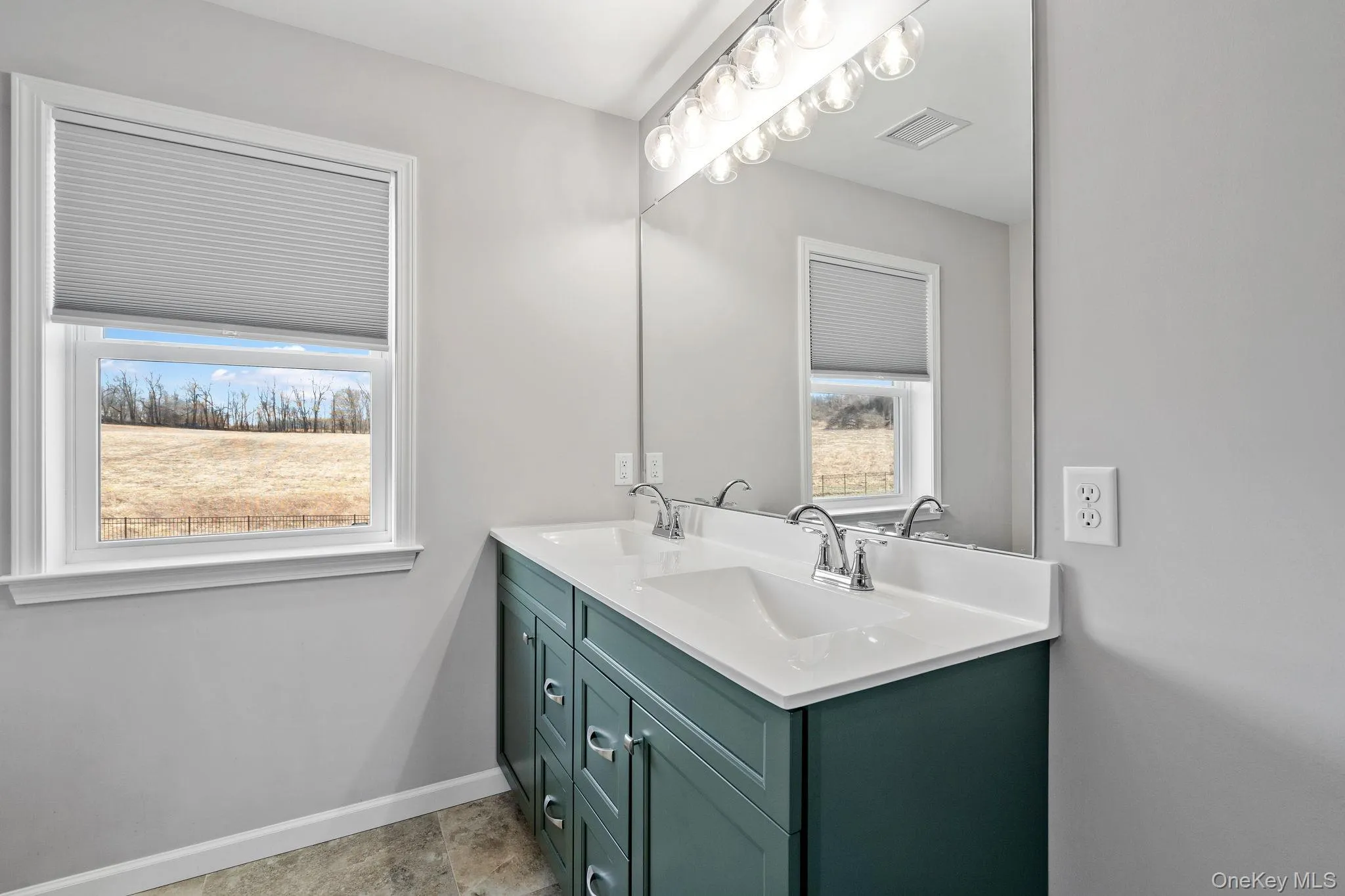 Full bathroom featuring double vanity and baseboards Full bathroom featuring double vanity and baseboards