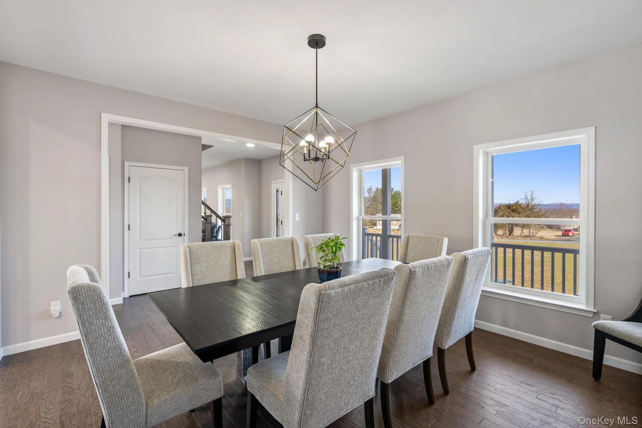 Dining space with dark wood finished floors, a chandelier, and stairs Dining space with dark wood finished floors, a chandelier, and stairs