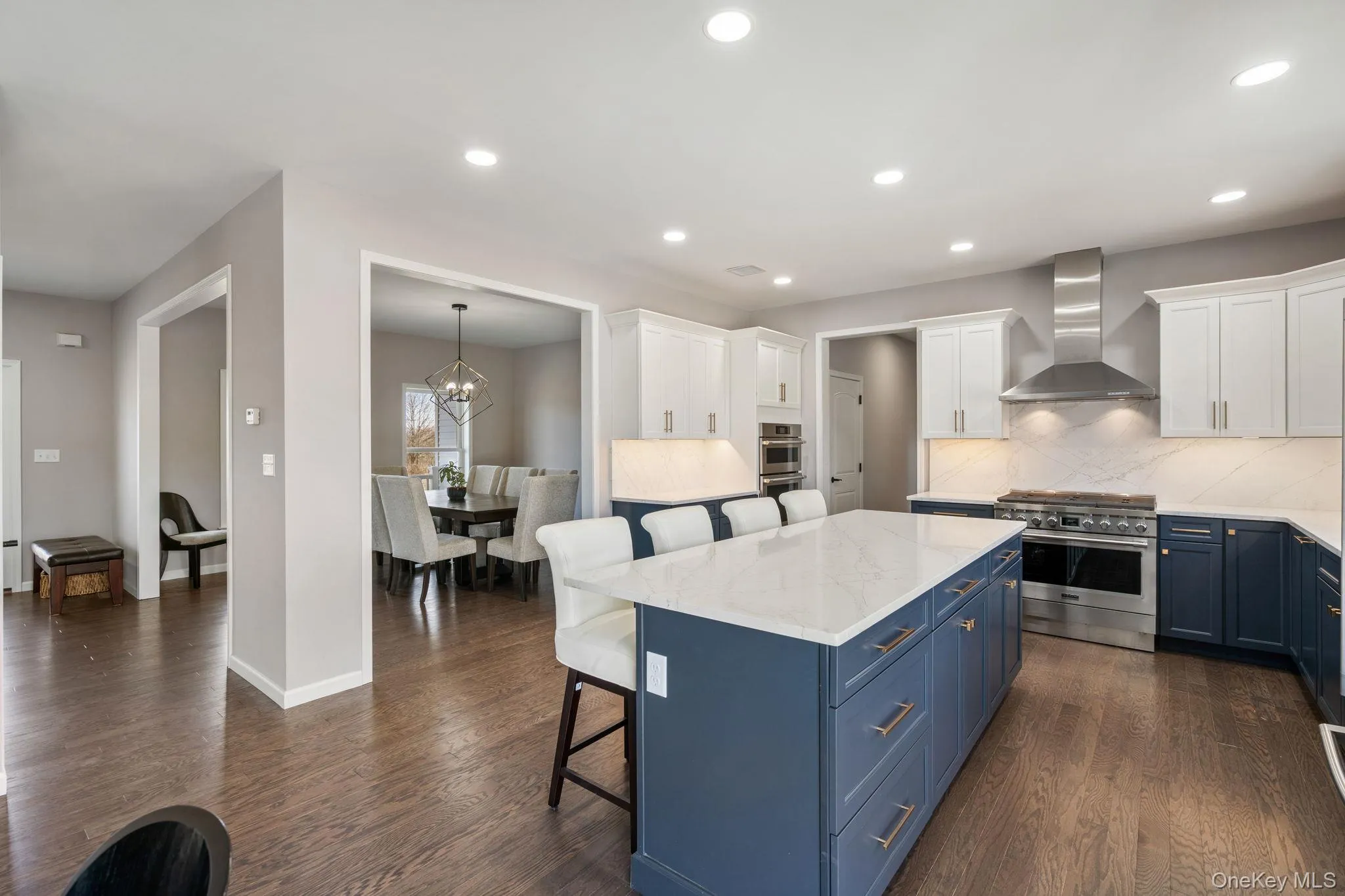 Kitchen with blue cabinets, a breakfast bar, stainless steel appliances, white cabinets, and tasteful backsplash Kitchen with blue cabinets, a breakfast bar, stainless steel appliances, white cabinets, and tasteful backsplash
