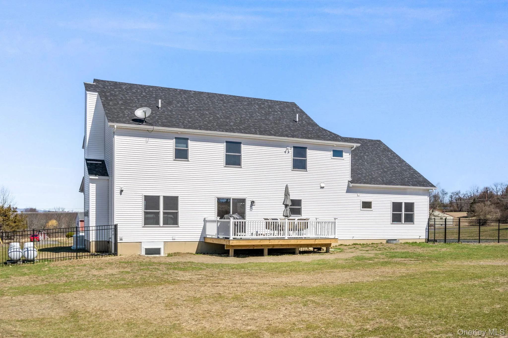 Back of property featuring a wooden deck and a shingled roof Back of property featuring a wooden deck and a shingled roof