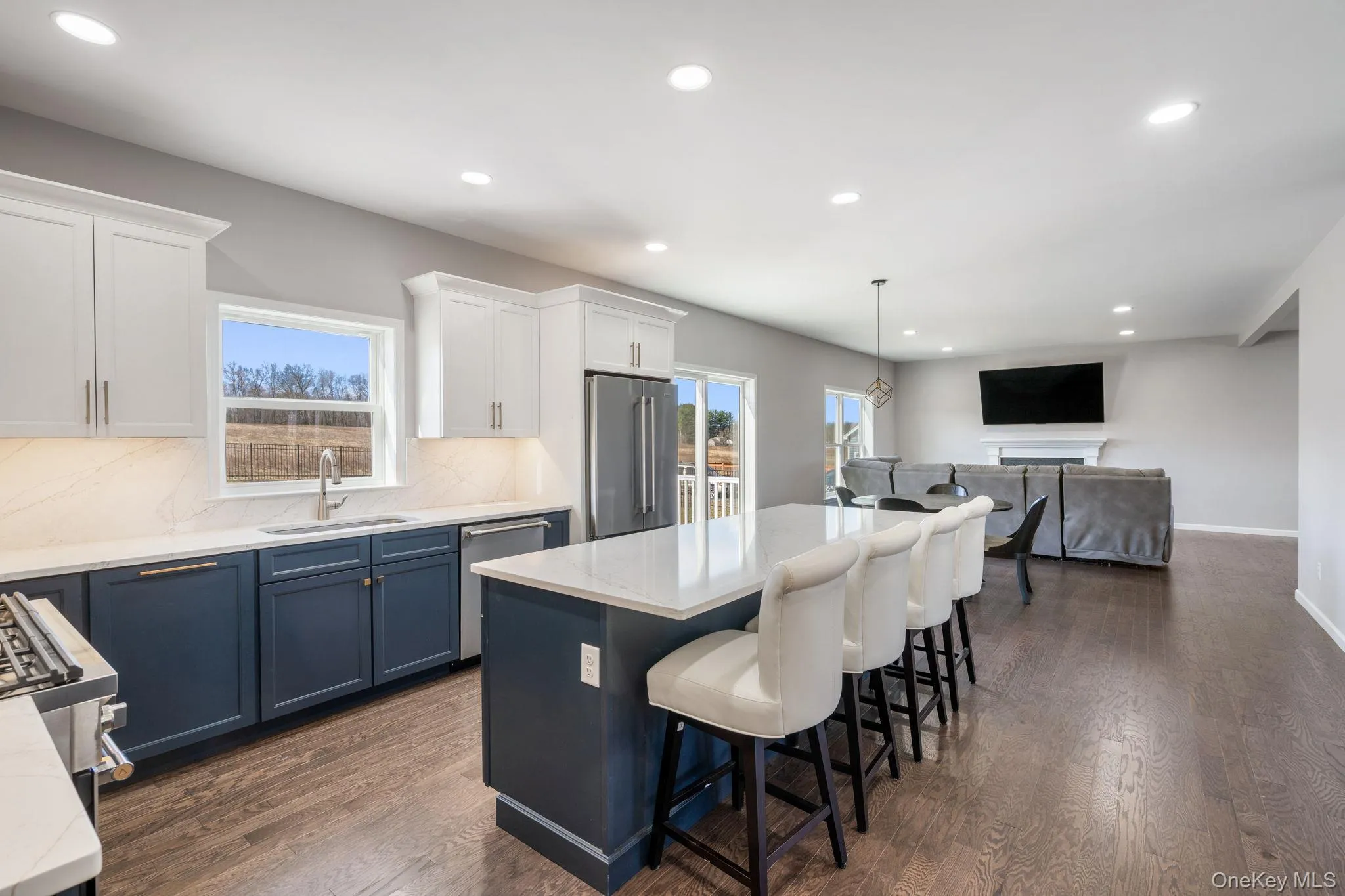Kitchen featuring blue cabinets, recessed lighting, decorative light fixtures, open floor plan, and tasteful backsplash Kitchen featuring blue cabinets, recessed lighting, decorative light fixtures, open floor plan, and tasteful backsplash