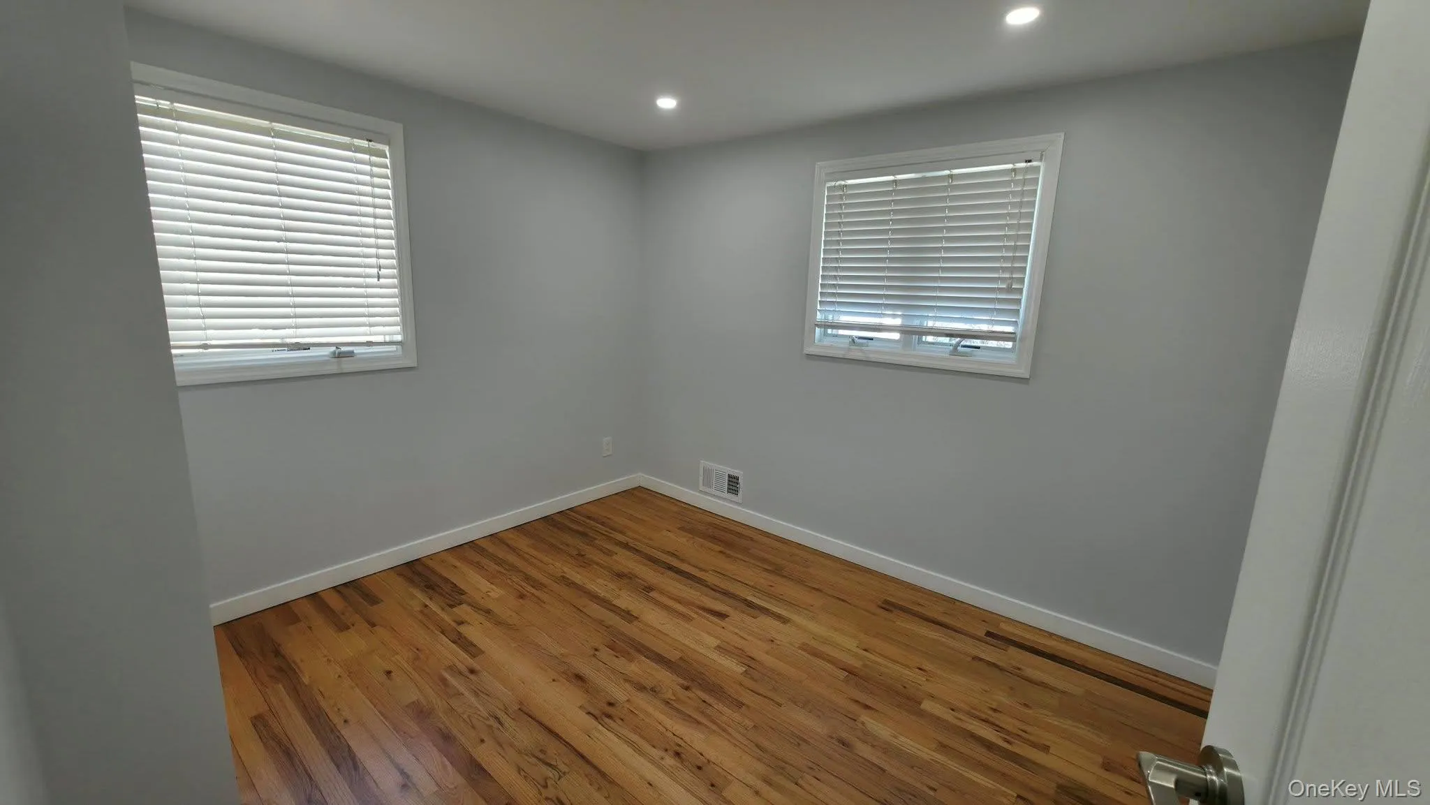 Empty room featuring hardwood / wood-style floors and recessed lighting Empty room featuring hardwood / wood-style floors and recessed lighting