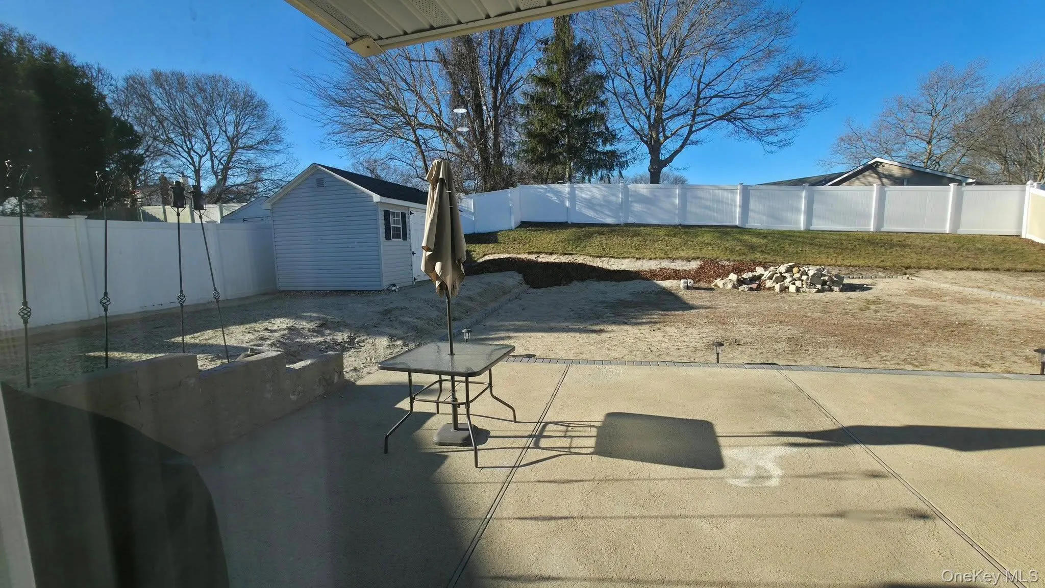 Fenced backyard with a patio and a storage shed Fenced backyard with a patio and a storage shed