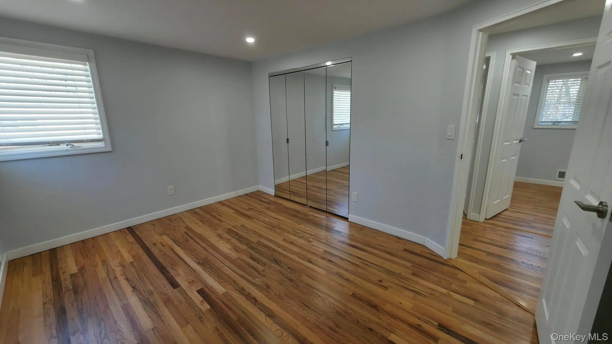 Unfurnished bedroom featuring recessed lighting, light wood finished floors, multiple windows, and a closet Unfurnished bedroom featuring recessed lighting, light wood finished floors, multiple windows, and a closet