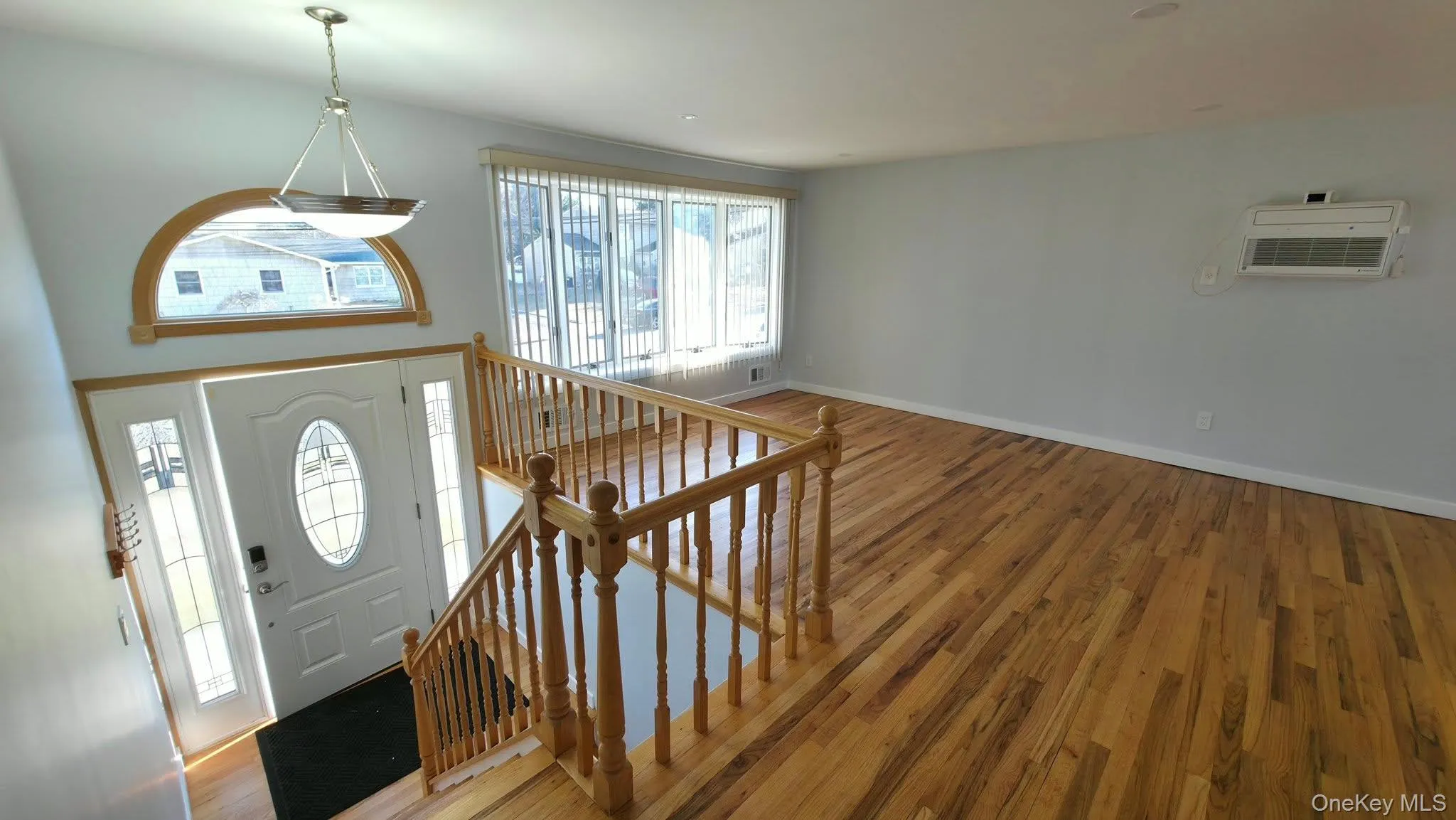 Foyer entrance with wood-type flooring and a wall mounted AC Foyer entrance with wood-type flooring and a wall mounted AC