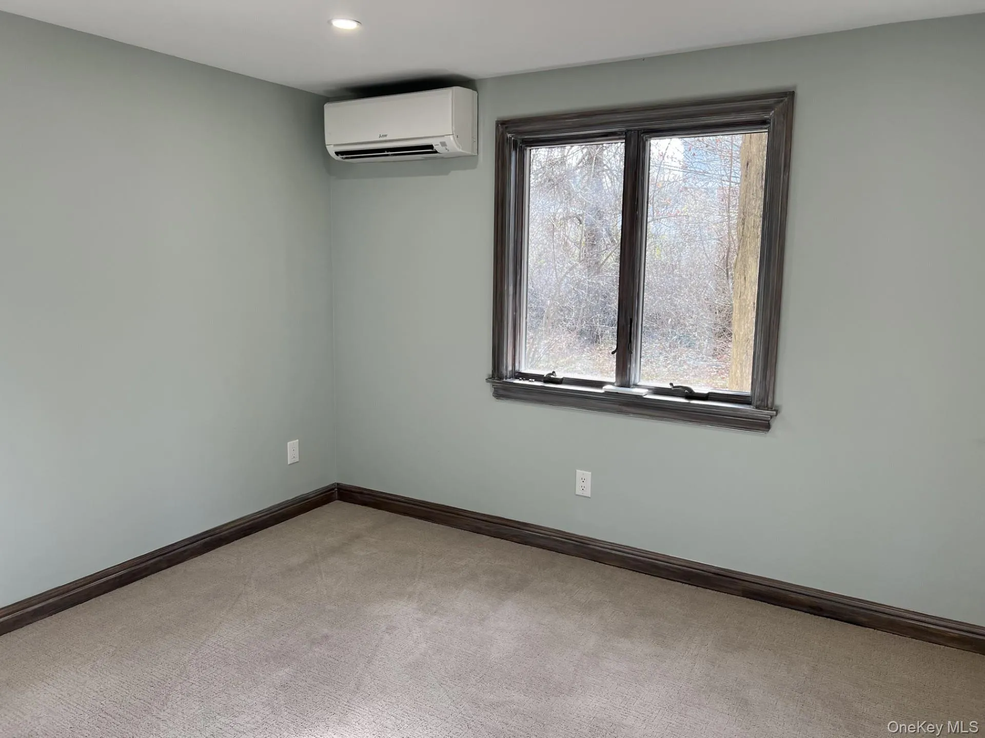 Unfurnished room featuring an AC wall unit, light colored carpet, and recessed lighting Unfurnished room featuring an AC wall unit, light colored carpet, and recessed lighting