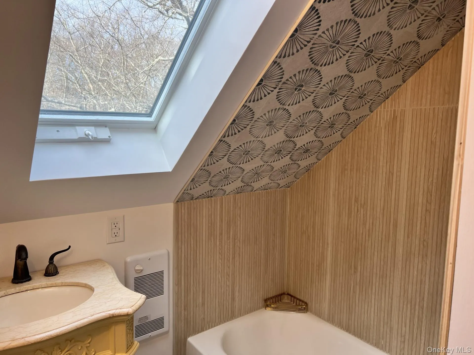 Full bathroom with a bathtub, heating unit, vanity, and a skylight Full bathroom with a bathtub, heating unit, vanity, and a skylight