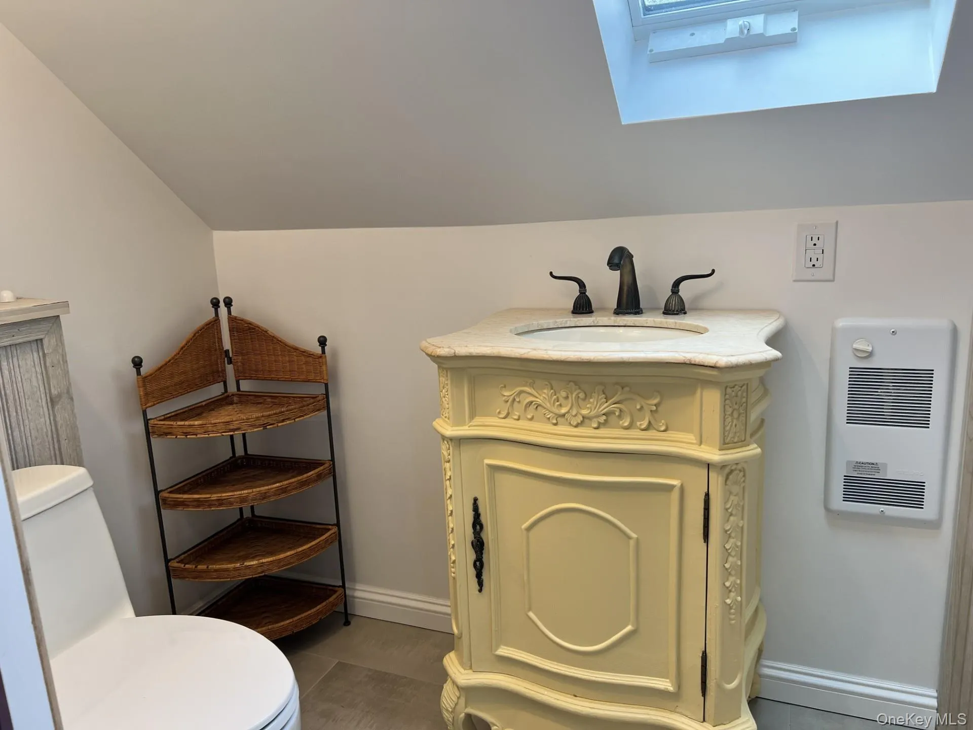 Bathroom with vanity, a skylight, and heating unit Bathroom with vanity, a skylight, and heating unit