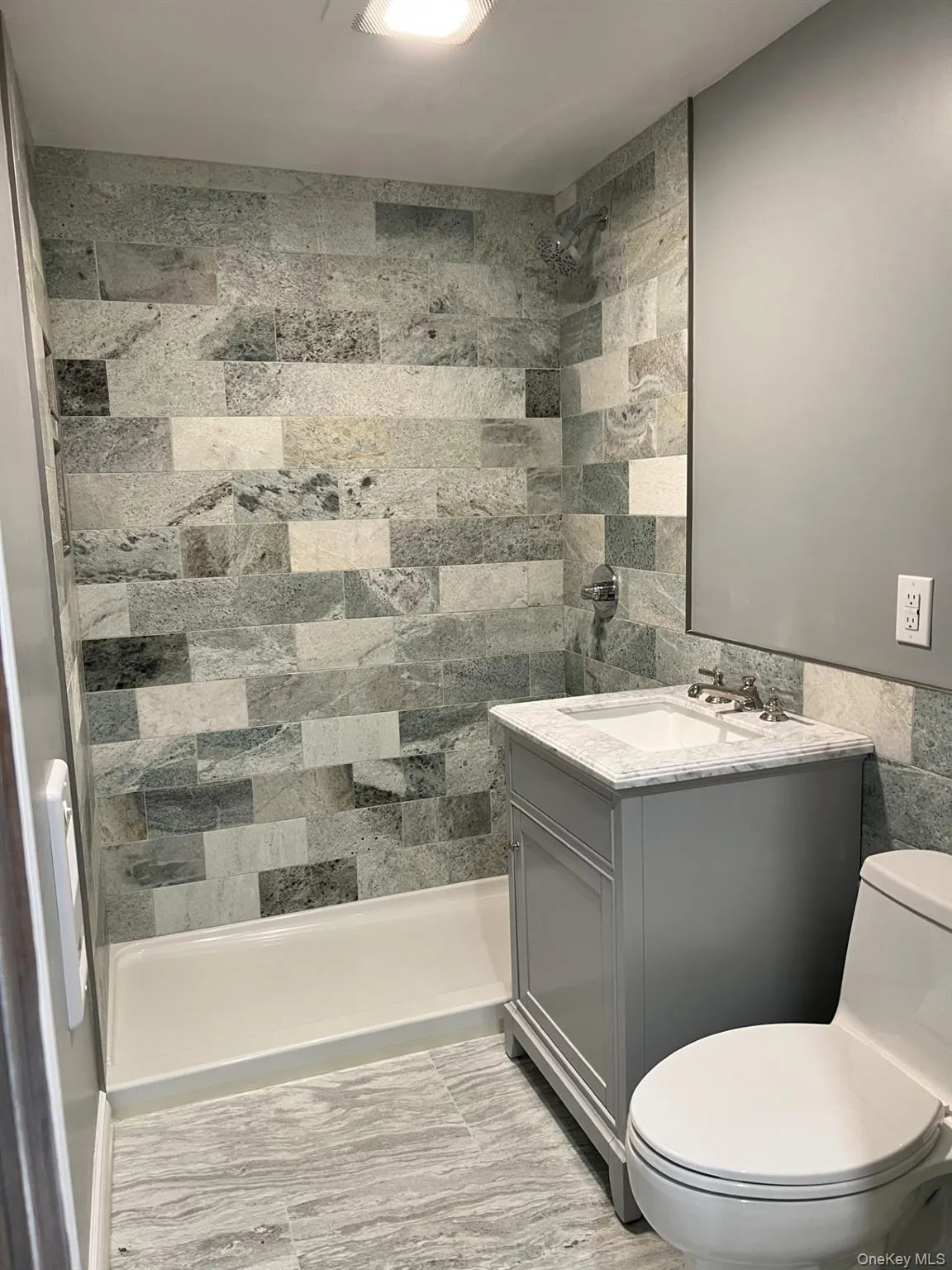 Full bath featuring tile walls, a shower stall, and vanity Full bath featuring tile walls, a shower stall, and vanity