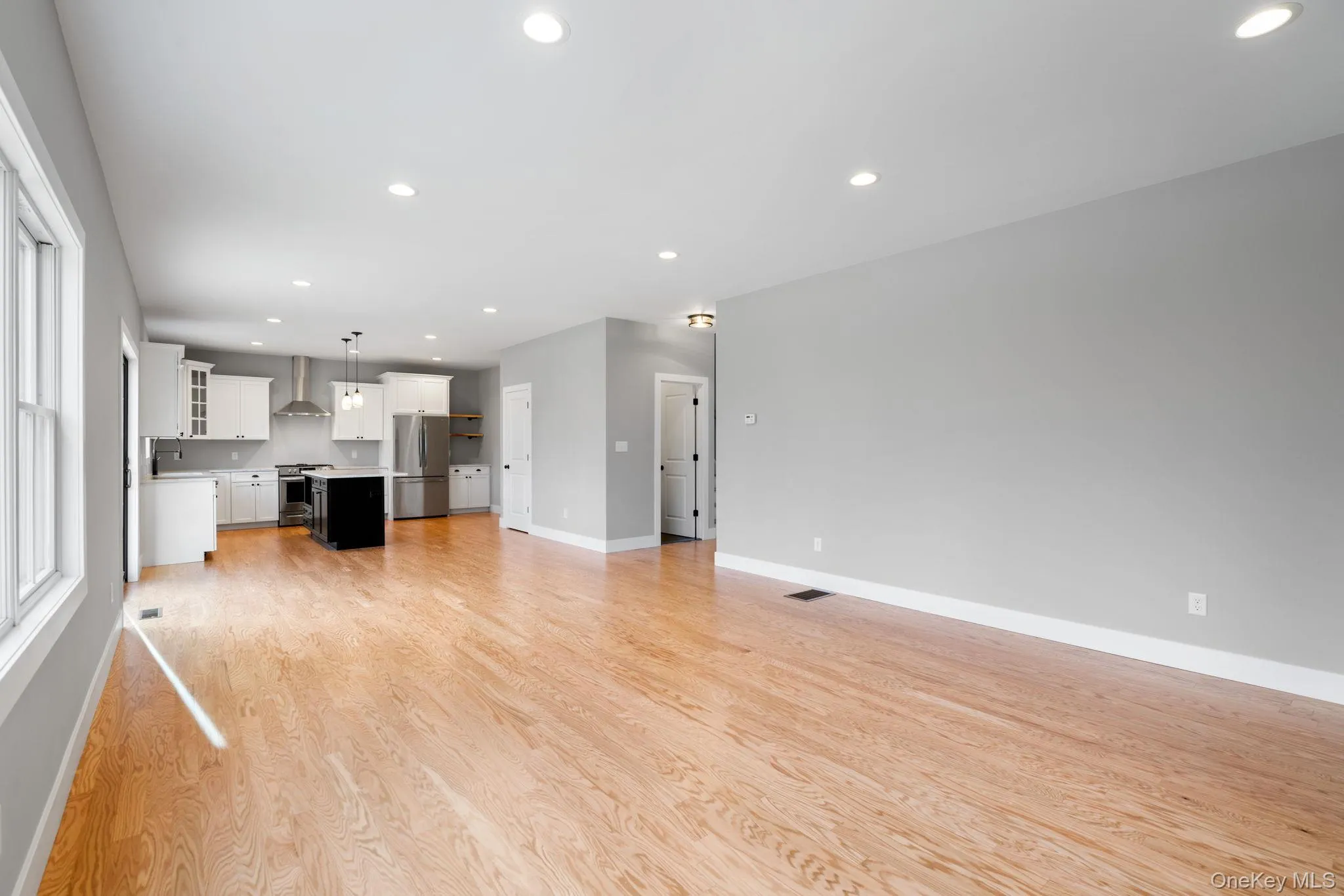 Unfurnished living room featuring recessed lighting and light wood finished floors Unfurnished living room featuring recessed lighting and light wood finished floors