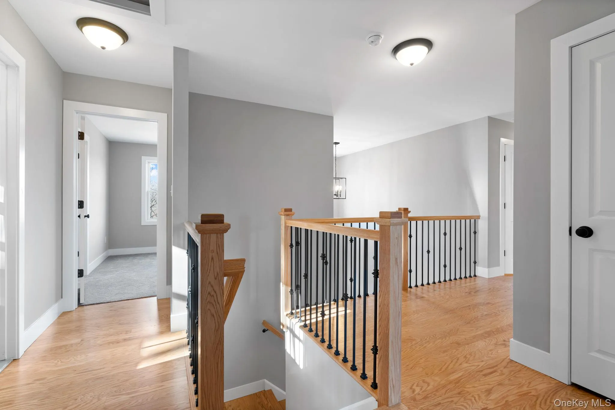 Hall featuring an upstairs landing and light wood-style flooring Hall featuring an upstairs landing and light wood-style flooring