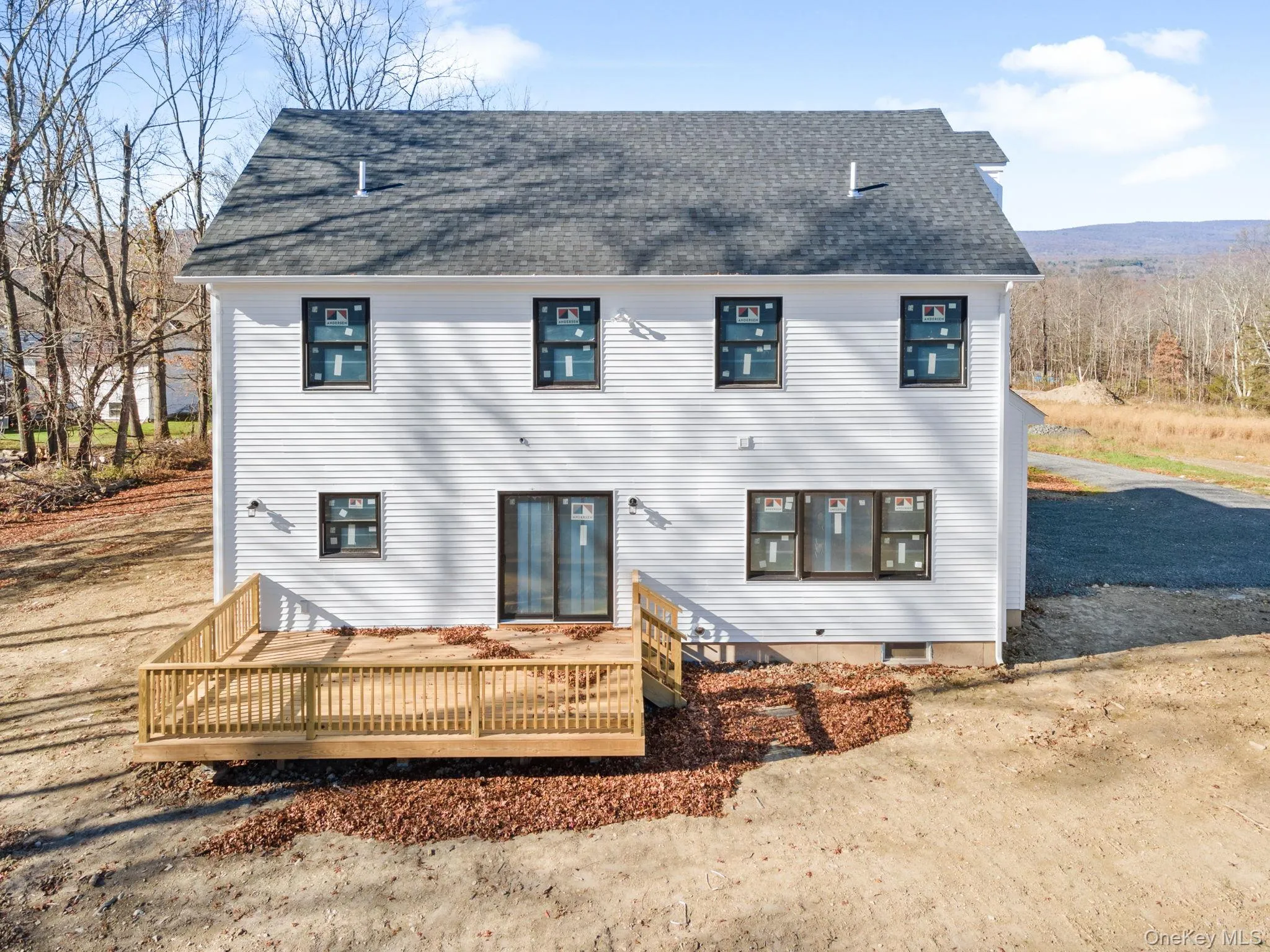 Back of house with a deck and a shingled roof Back of house with a deck and a shingled roof