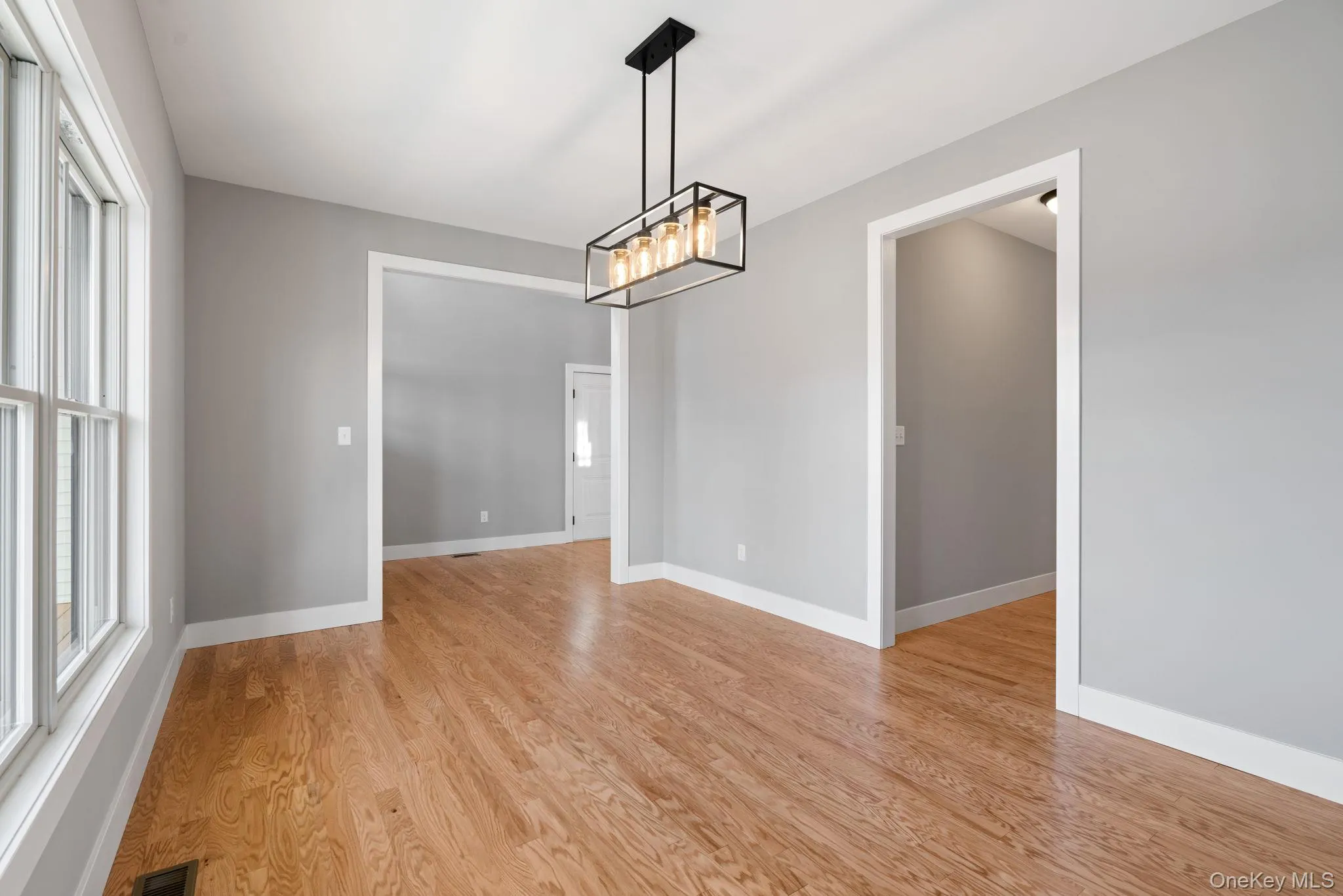 Unfurnished dining area with light wood-style flooring and a chandelier Unfurnished dining area with light wood-style flooring and a chandelier