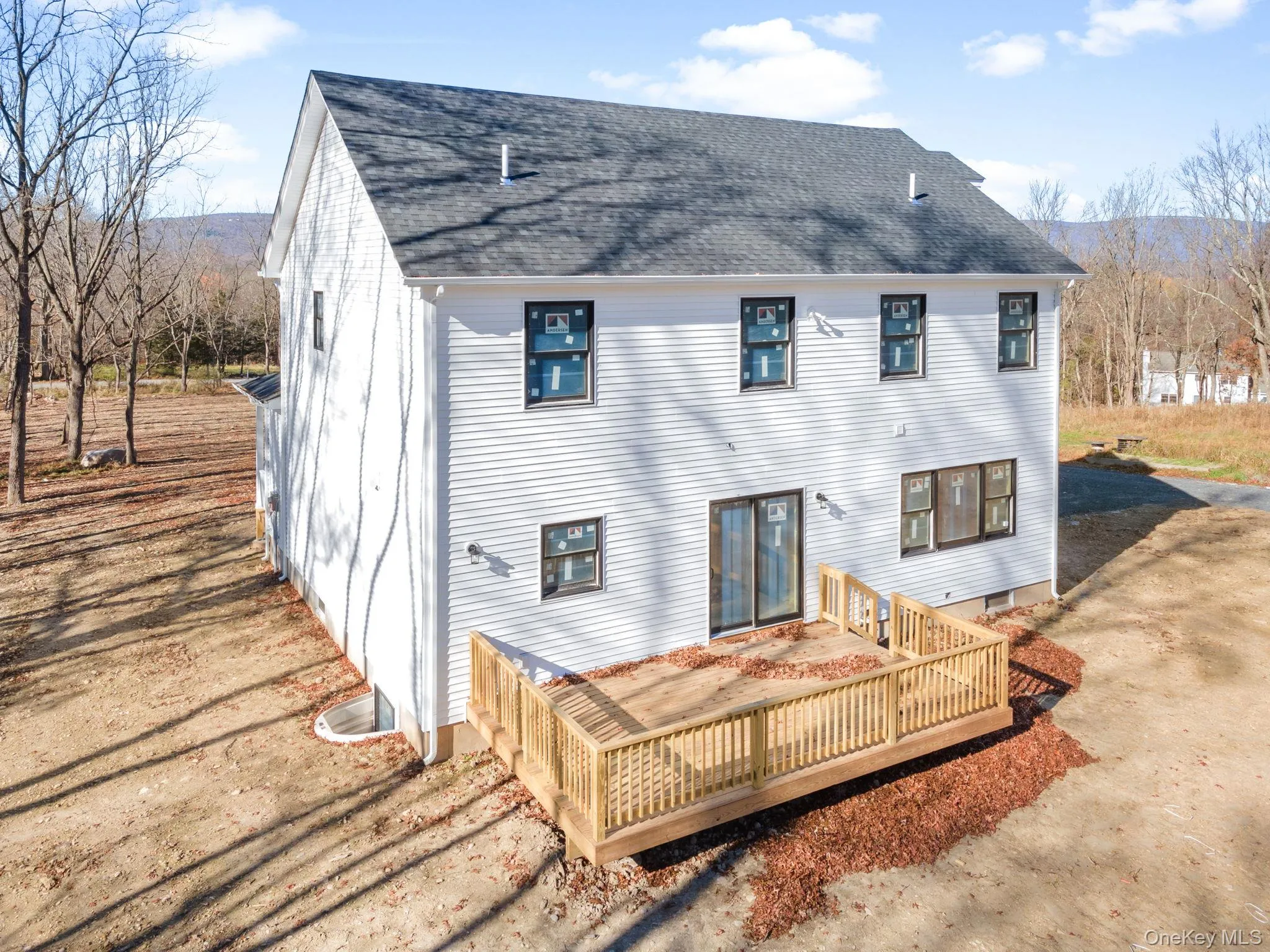 Back of property with a wooden deck and a shingled roof Back of property with a wooden deck and a shingled roof