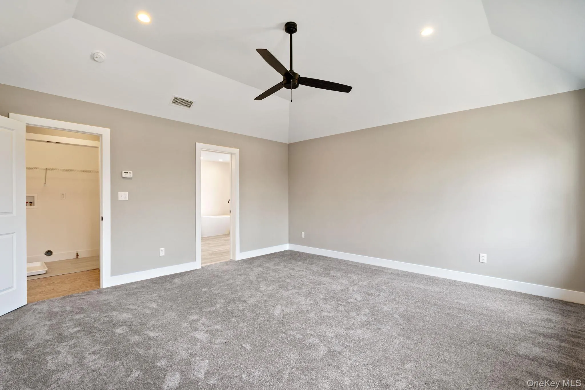 Unfurnished bedroom featuring lofted ceiling, ensuite bath, light colored carpet, ceiling fan, and recessed lighting Unfurnished bedroom featuring lofted ceiling, ensuite bath, light colored carpet, ceiling fan, and recessed lighting