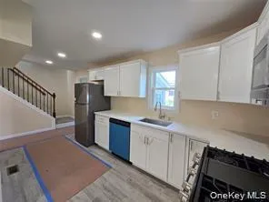 Kitchen featuring white cabinets, appliances with stainless steel finishes, light countertops, light wood-style flooring, and recessed lighting Kitchen featuring white cabinets, appliances with stainless steel finishes, light countertops, light wood-style flooring, and recessed lighting