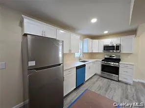 Kitchen with appliances with stainless steel finishes, white cabinetry, light countertops, recessed lighting, and light wood-style floors Kitchen with appliances with stainless steel finishes, white cabinetry, light countertops, recessed lighting, and light wood-style floors