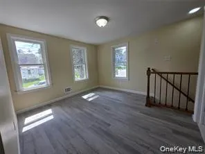 Spare room with dark wood-type flooring and baseboards Spare room with dark wood-type flooring and baseboards