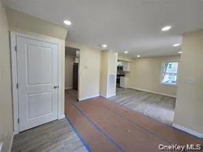 Unfurnished living room featuring wood finished floors and recessed lighting Unfurnished living room featuring wood finished floors and recessed lighting