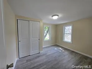 Unfurnished bedroom featuring wood finished floors and a closet Unfurnished bedroom featuring wood finished floors and a closet