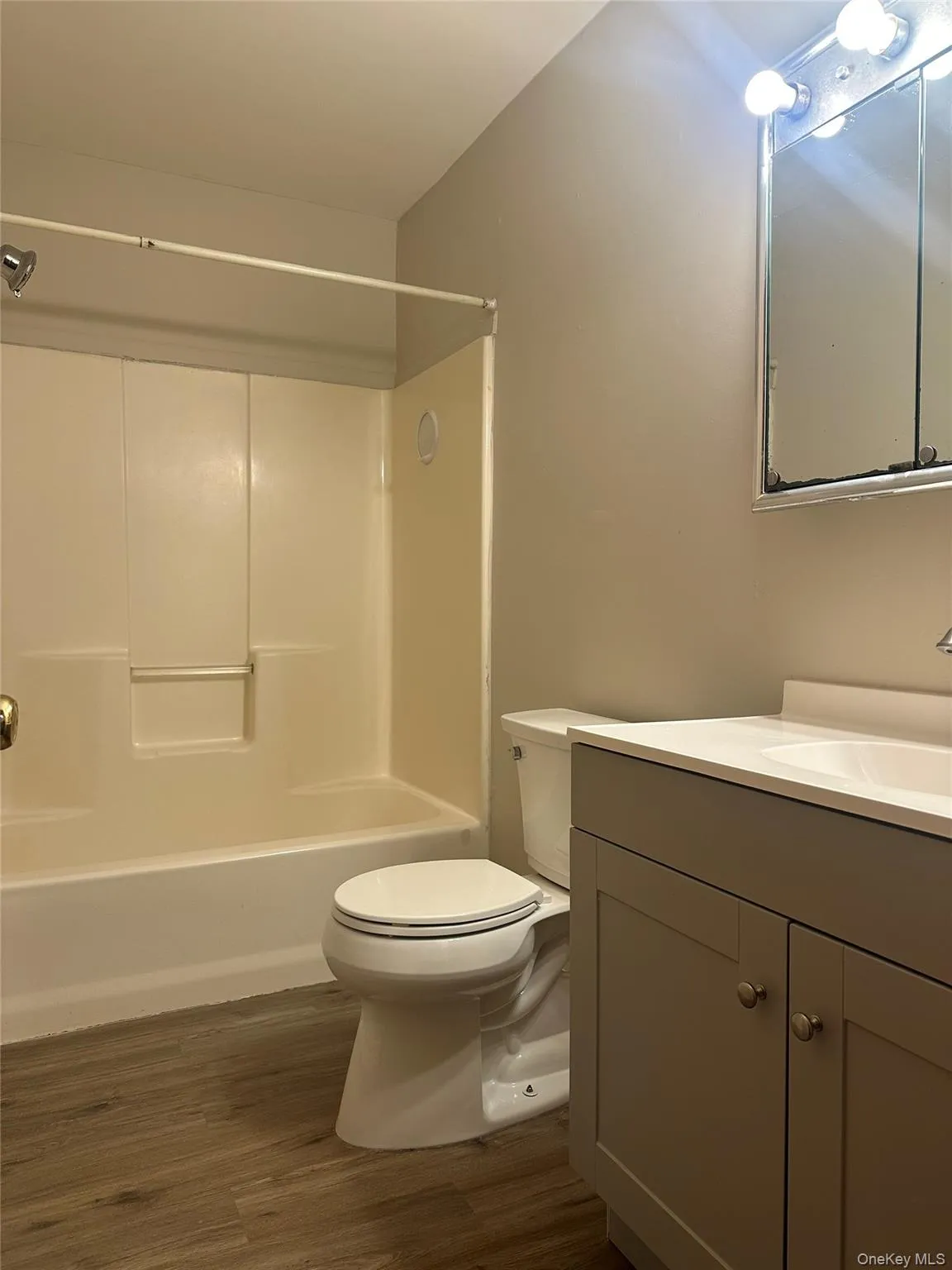 Full bath featuring vanity, dark wood finished floors, and bathing tub / shower combination Full bath featuring vanity, dark wood finished floors, and bathing tub / shower combination