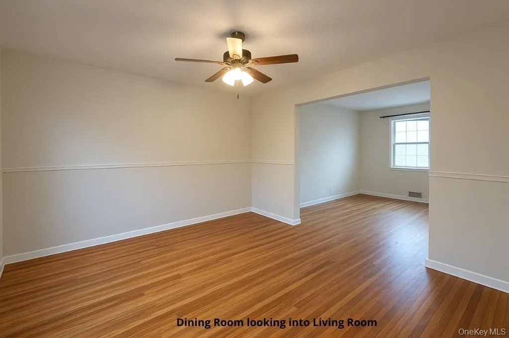 Spare room with wood finished floors and ceiling fan Spare room with wood finished floors and ceiling fan