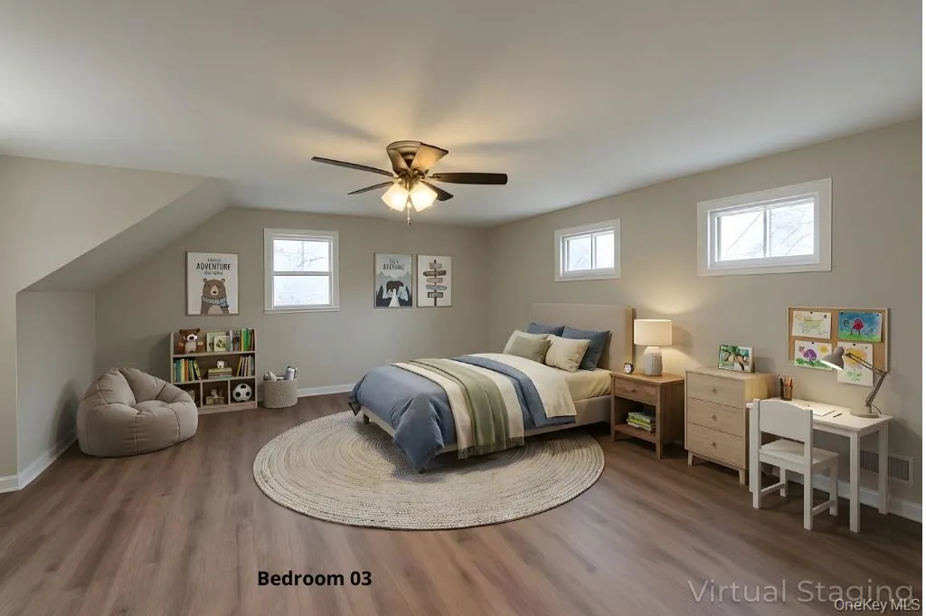 Bedroom with multiple windows, wood finished floors, and a ceiling fan Bedroom with multiple windows, wood finished floors, and a ceiling fan