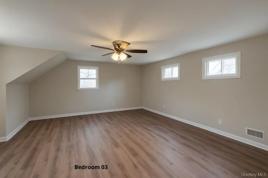 Bonus room with dark wood-type flooring, healthy amount of natural light, and a ceiling fan Bonus room with dark wood-type flooring, healthy amount of natural light, and a ceiling fan