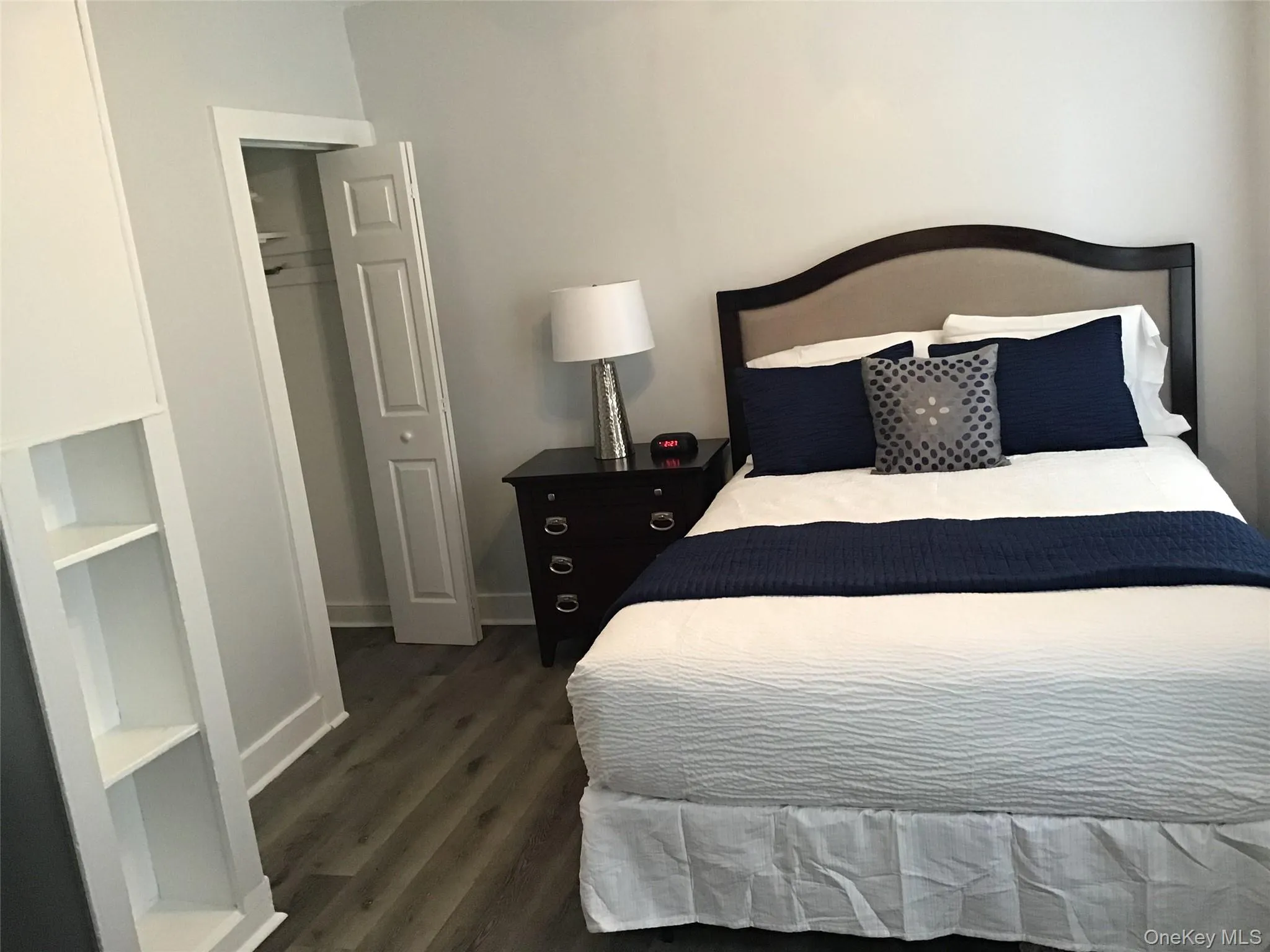 Bedroom with dark wood finished floors and baseboards Bedroom with dark wood finished floors and baseboards