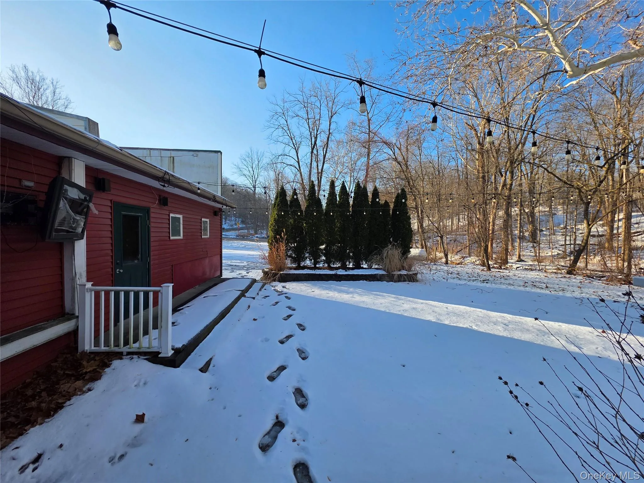 Yard layered in snow featuring a wooden deck Yard layered in snow featuring a wooden deck