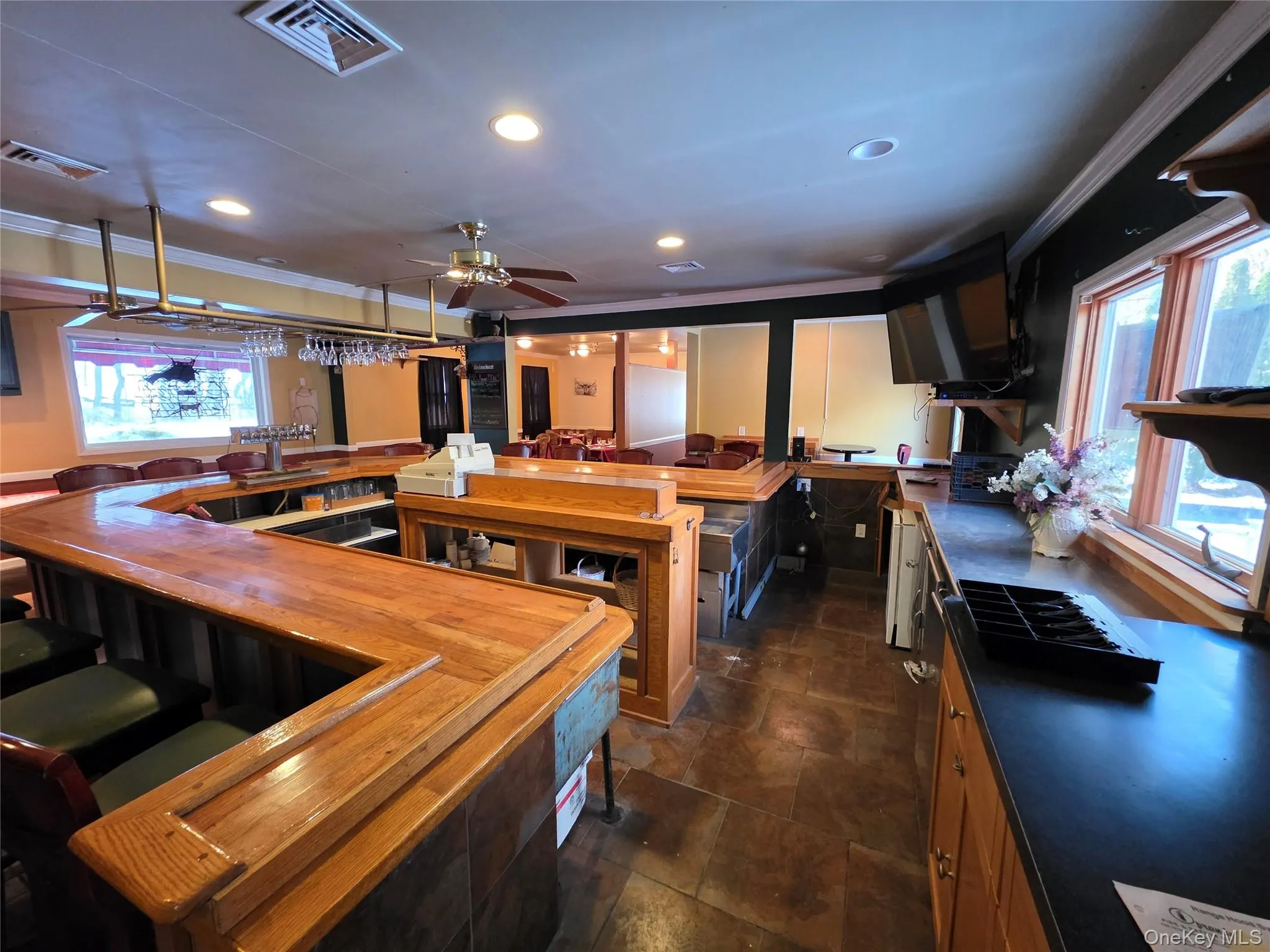 Kitchen featuring plenty of natural light, a kitchen bar, ornamental molding, a ceiling fan, and recessed lighting Kitchen featuring plenty of natural light, a kitchen bar, ornamental molding, a ceiling fan, and recessed lighting