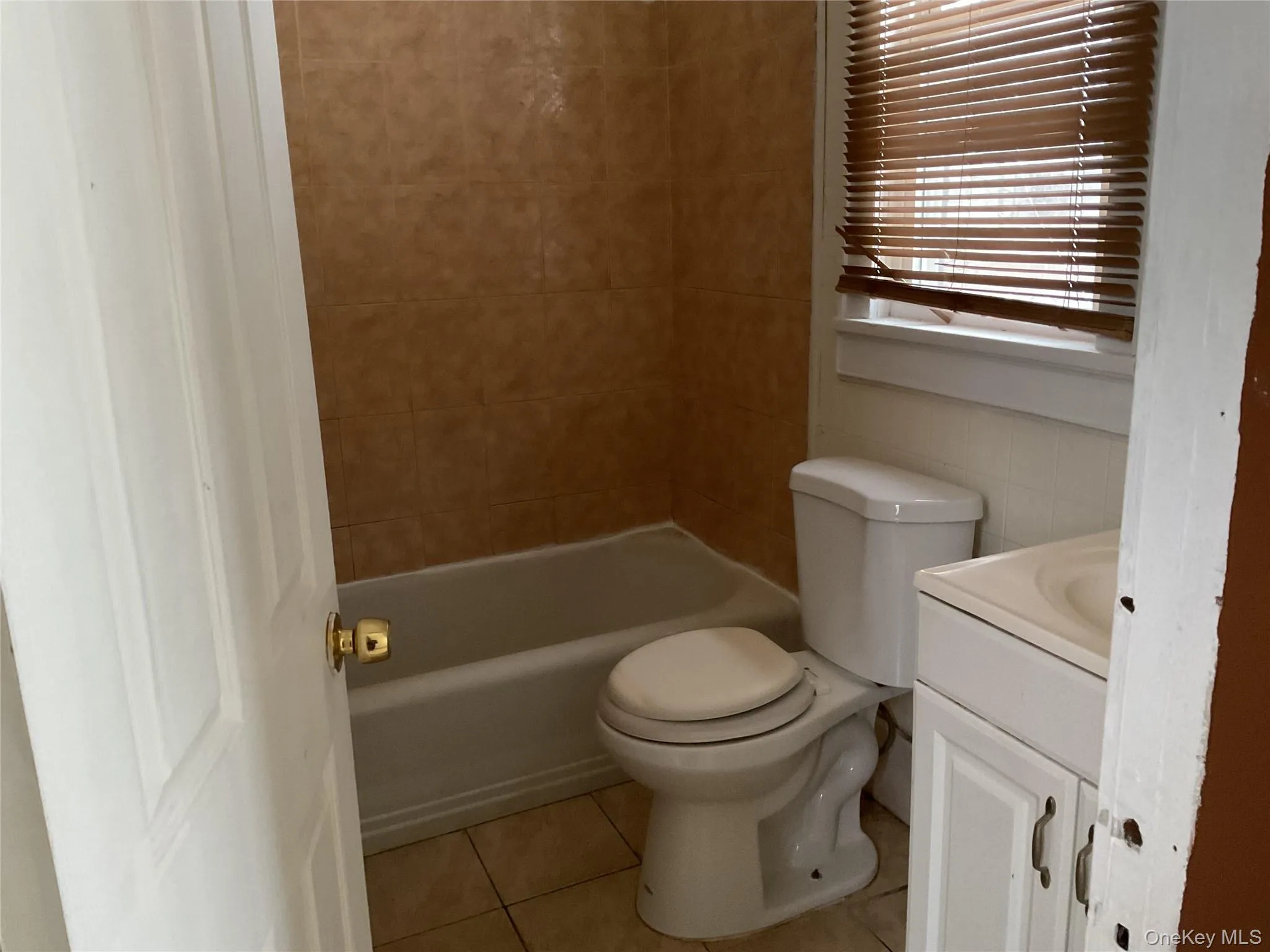 Full bathroom featuring vanity, light tile patterned flooring, and shower / tub combination Full bathroom featuring vanity, light tile patterned flooring, and shower / tub combination