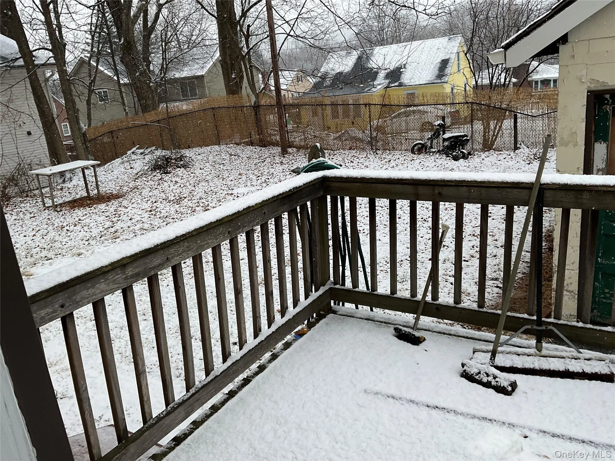 Snow covered deck with a residential view and a fenced backyard Snow covered deck with a residential view and a fenced backyard