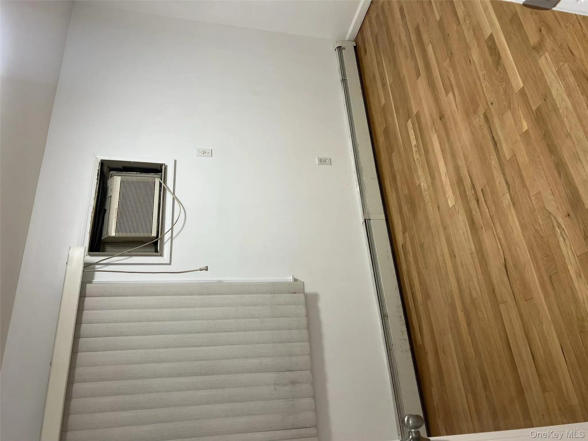 Empty room with a baseboard radiator and wood finished floors Empty room with a baseboard radiator and wood finished floors