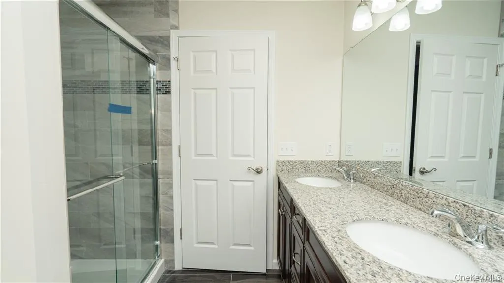 Full bathroom with double vanity and a shower stall Full bathroom with double vanity and a shower stall