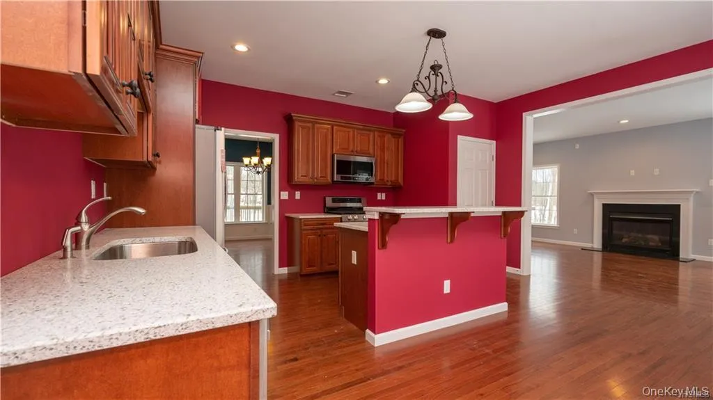 Kitchen featuring recessed lighting, a chandelier, hanging light fixtures, a breakfast bar, and open floor plan Kitchen featuring recessed lighting, a chandelier, hanging light fixtures, a breakfast bar, and open floor plan