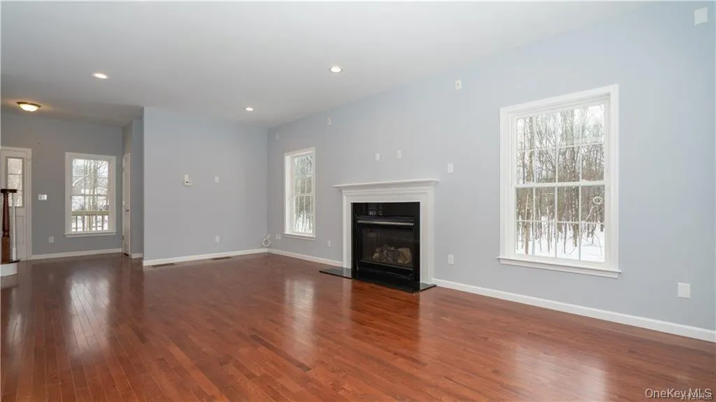 Unfurnished living room with a glass covered fireplace, recessed lighting, and dark wood finished floors Unfurnished living room with a glass covered fireplace, recessed lighting, and dark wood finished floors