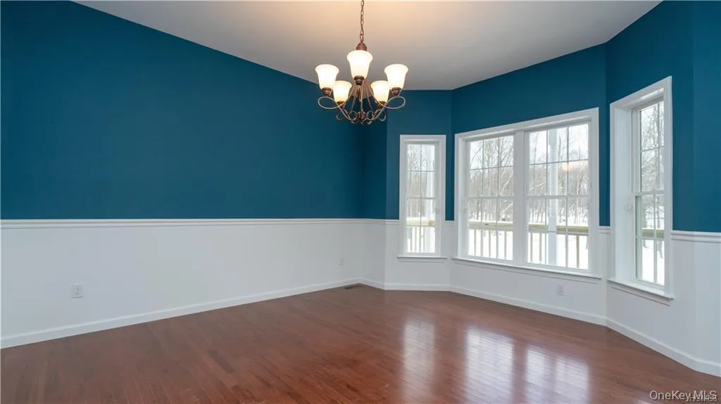Spare room with a chandelier and dark wood finished floors Spare room with a chandelier and dark wood finished floors