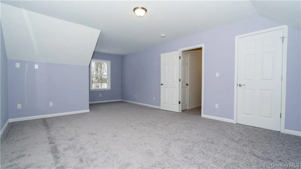 Bonus room featuring light colored carpet and vaulted ceiling Bonus room featuring light colored carpet and vaulted ceiling