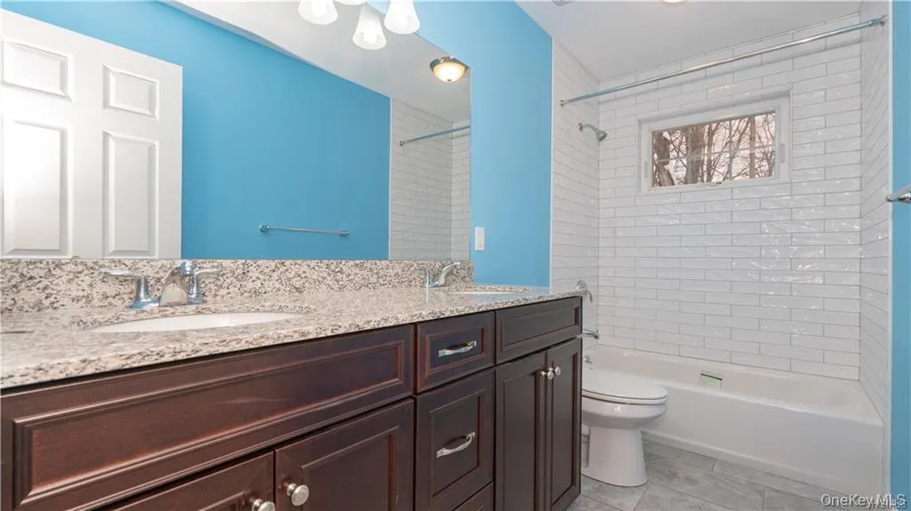 Full bath with shower / tub combination, double vanity, and light tile patterned flooring Full bath with shower / tub combination, double vanity, and light tile patterned flooring