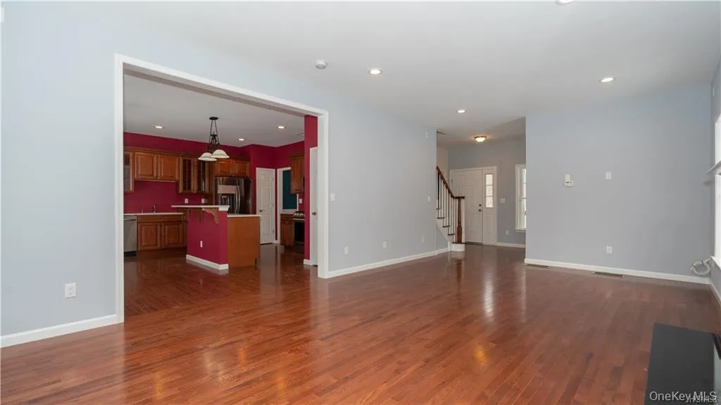 Unfurnished living room with stairs, recessed lighting, and dark wood finished floors Unfurnished living room with stairs, recessed lighting, and dark wood finished floors