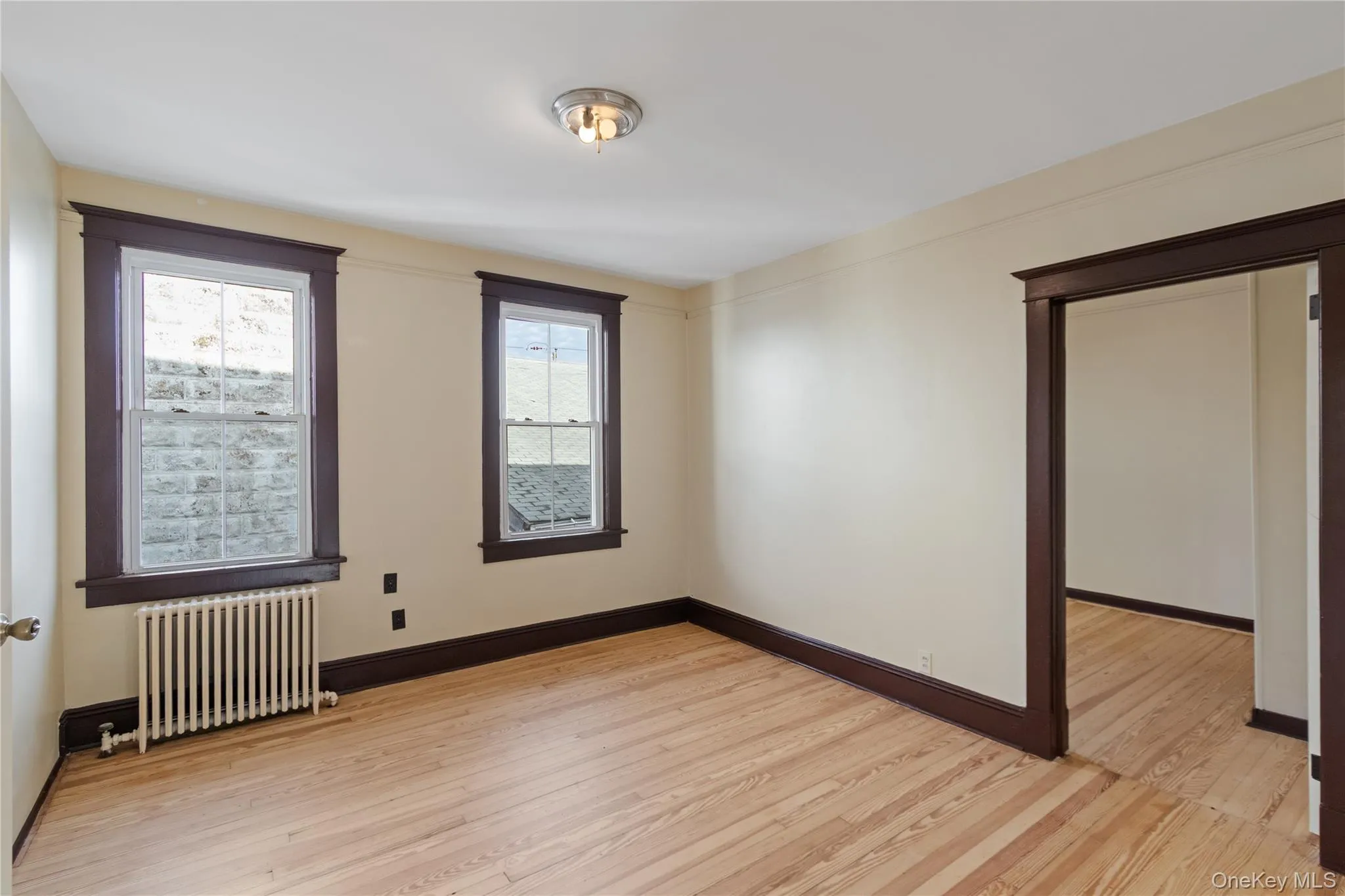 Spare room with radiator heating unit and light wood-style floors Spare room with radiator heating unit and light wood-style floors