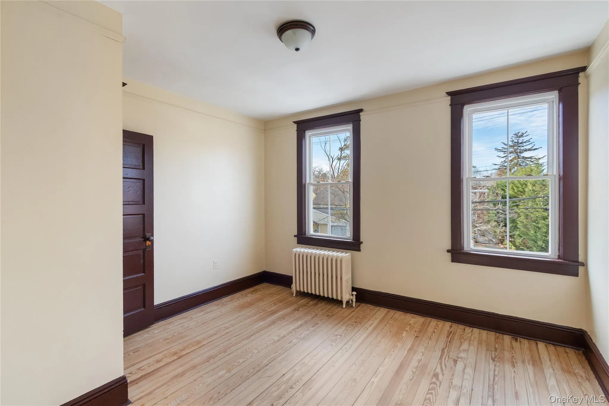 Spare room featuring radiator and light wood-type flooring Spare room featuring radiator and light wood-type flooring