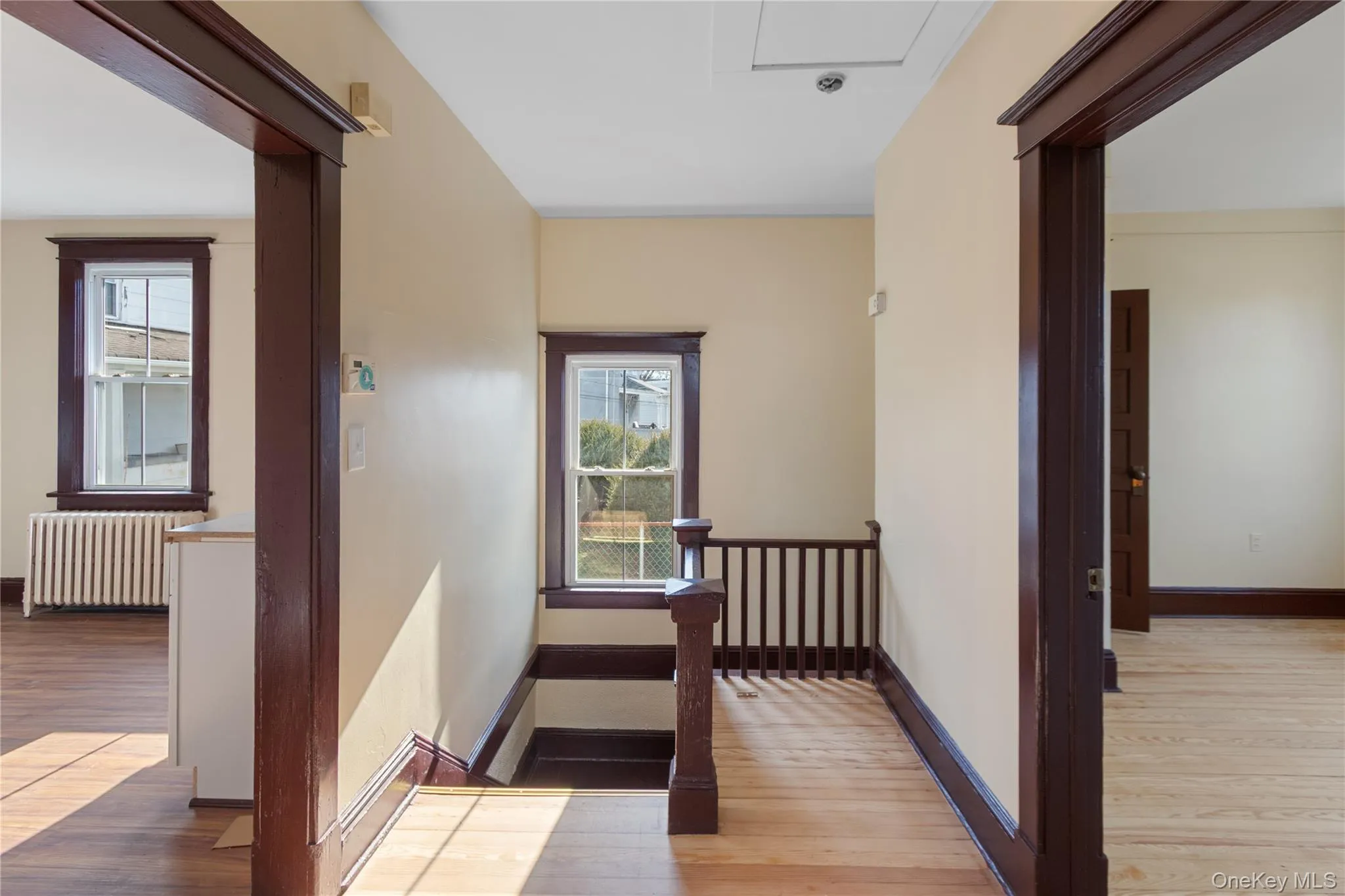 Hall featuring light wood-style floors and radiator heating unit Hall featuring light wood-style floors and radiator heating unit