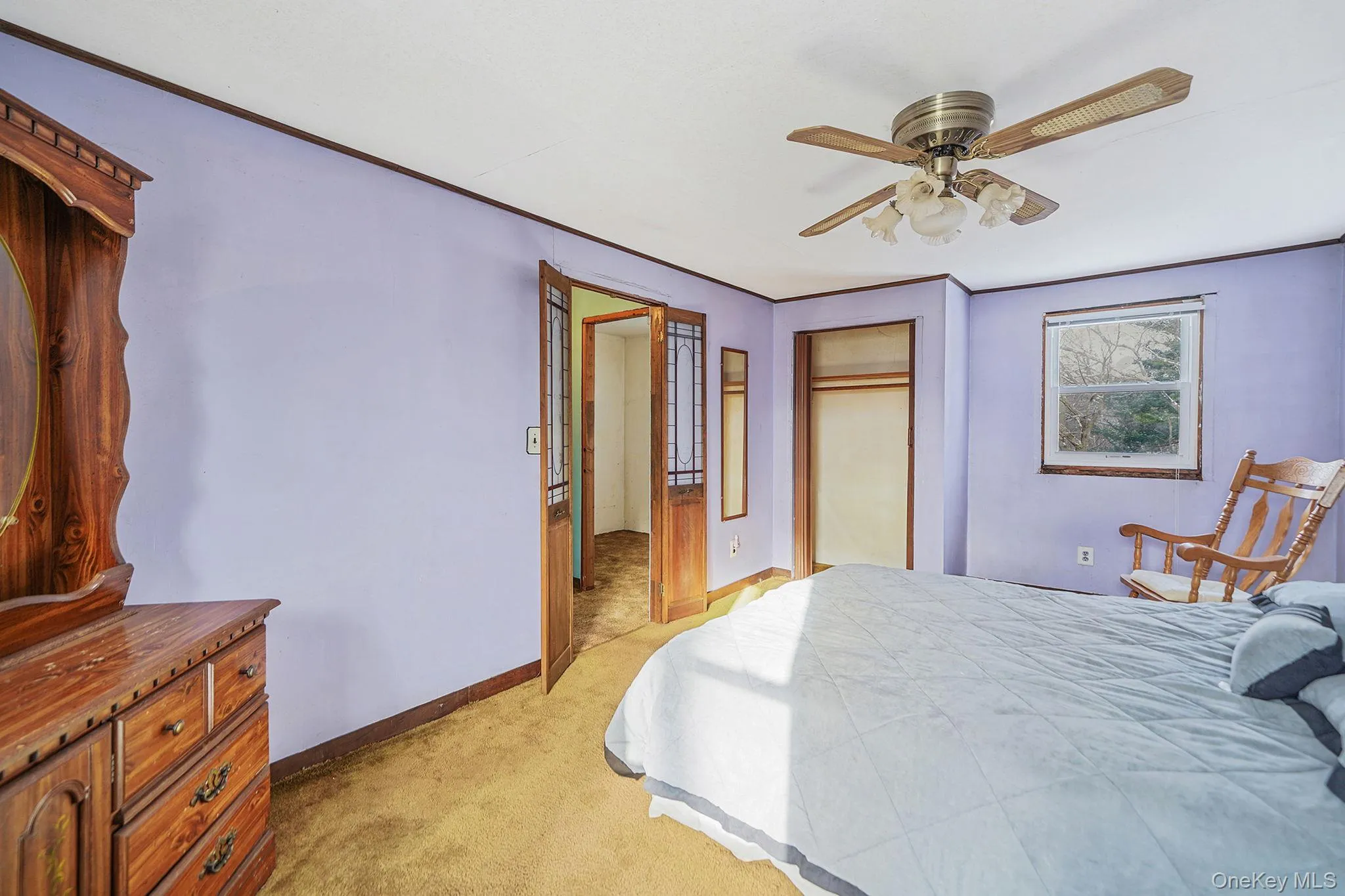Bedroom featuring light colored carpet, a closet, ceiling fan, and ornamental molding Bedroom featuring light colored carpet, a closet, ceiling fan, and ornamental molding