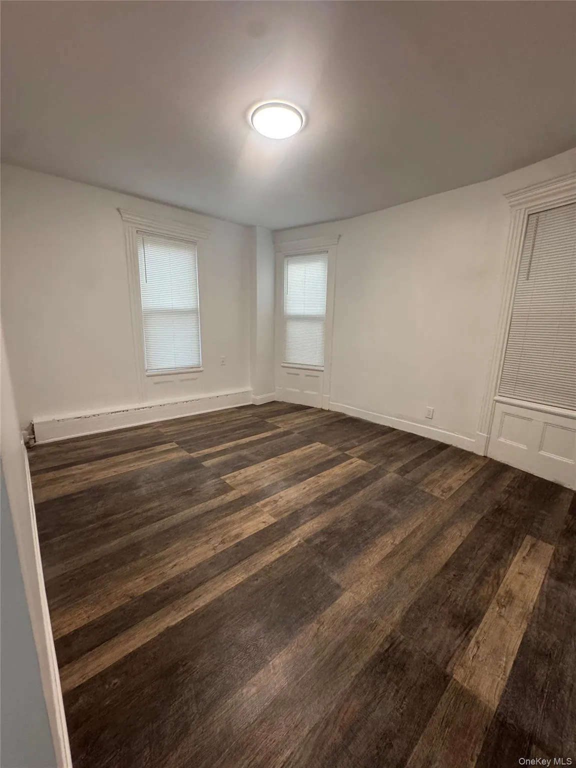 Empty room featuring dark wood finished floors and baseboards Empty room featuring dark wood finished floors and baseboards