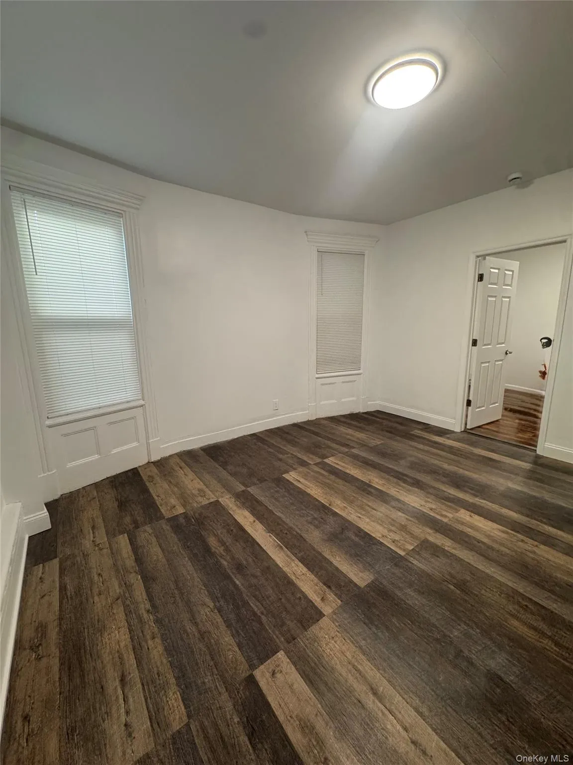 Unfurnished bedroom featuring baseboards and dark wood-style flooring Unfurnished bedroom featuring baseboards and dark wood-style flooring