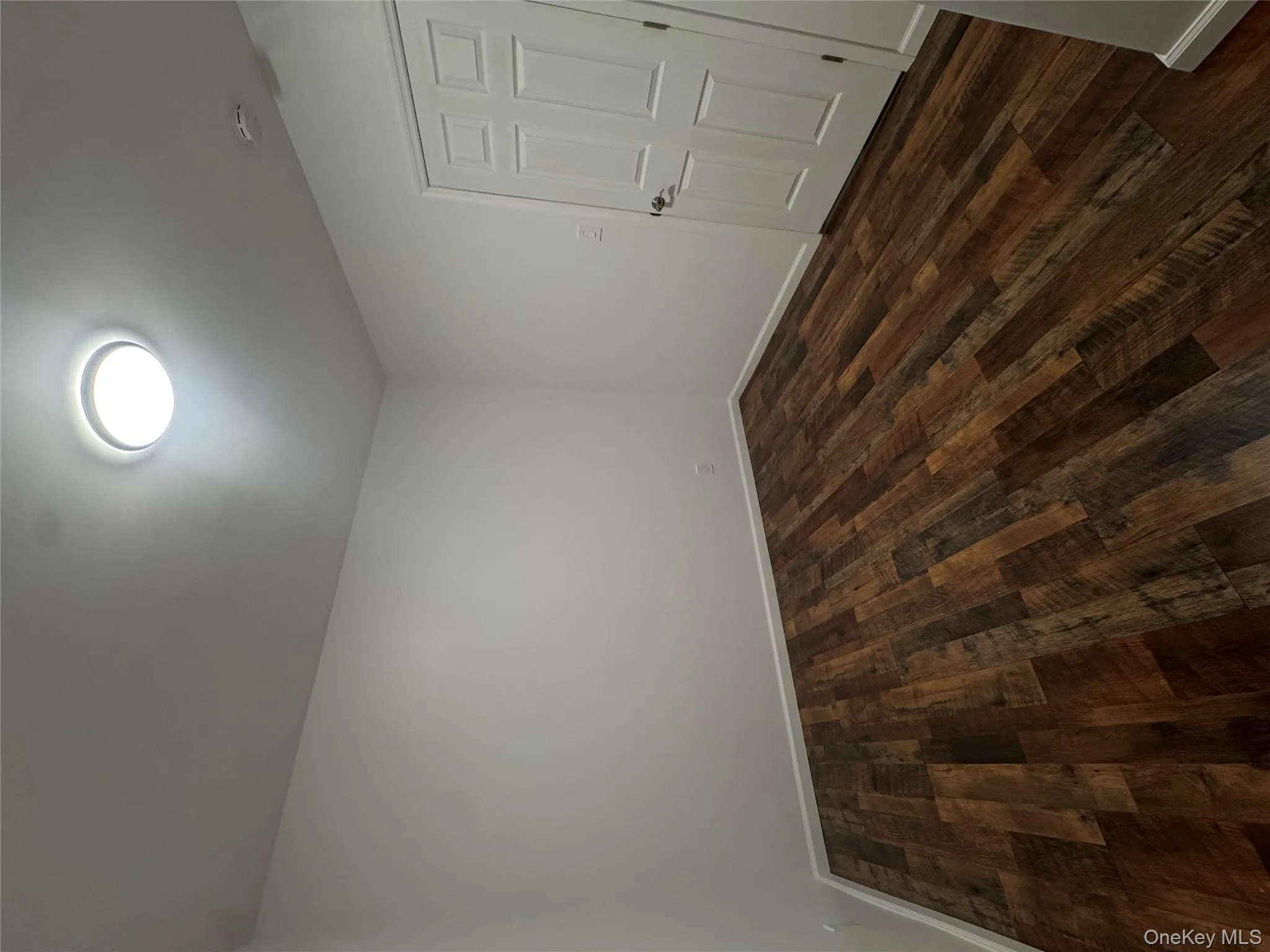 Spare room featuring dark wood-style flooring and baseboards Spare room featuring dark wood-style flooring and baseboards