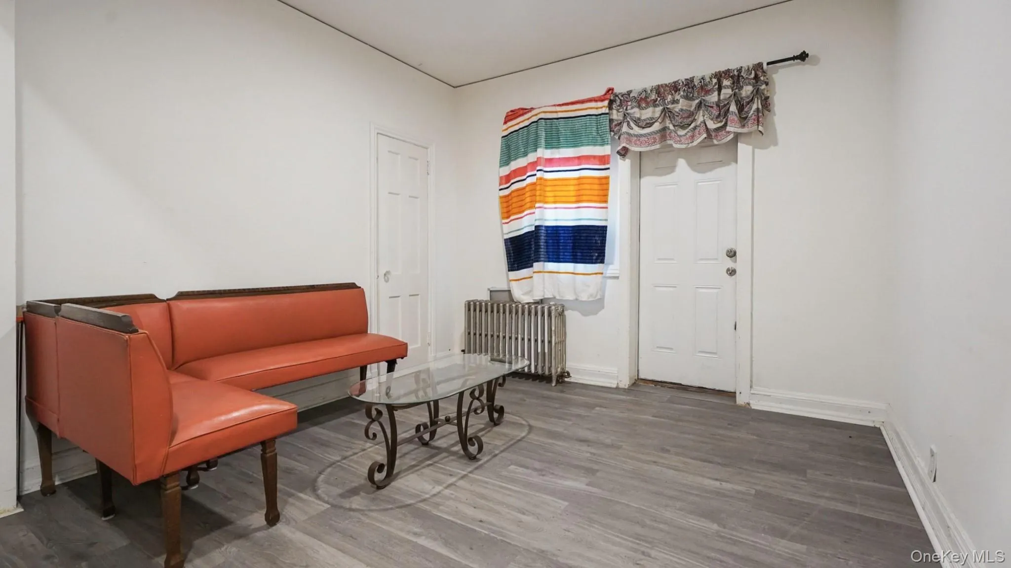 Sitting room featuring radiator heating unit and wood finished floors Sitting room featuring radiator heating unit and wood finished floors